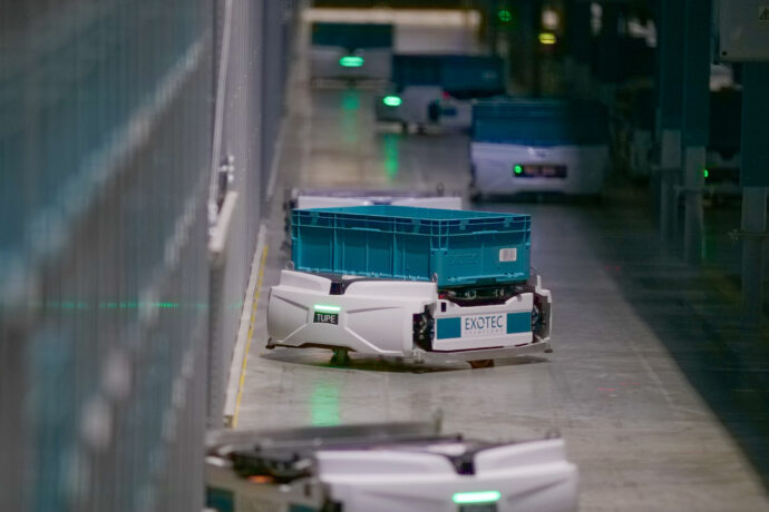 A line of blue and white Exotec's automated warehouse robots.