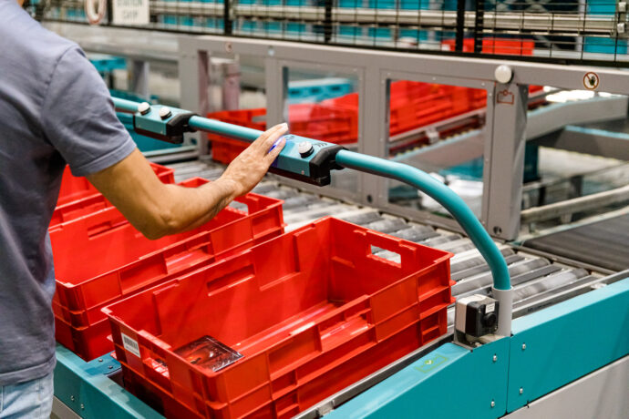 A man operating Exotec's Put-to-Light system in a warehouse.