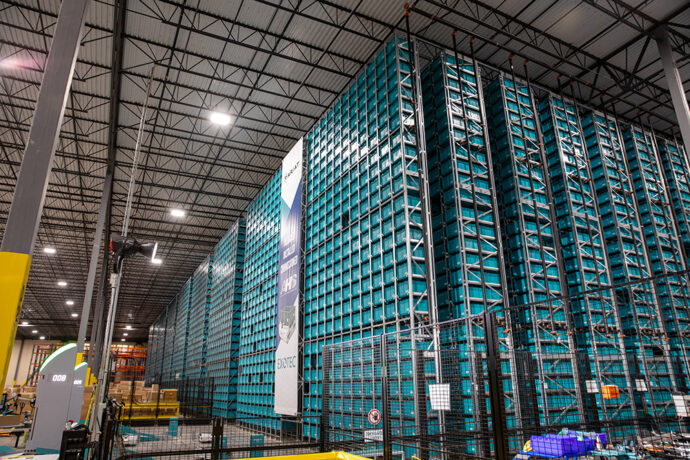 A large warehouse with a lot of racks and crates.