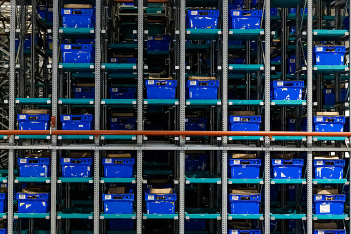 A picture of bins in racks in a warehouse for a grocery industry storage system.