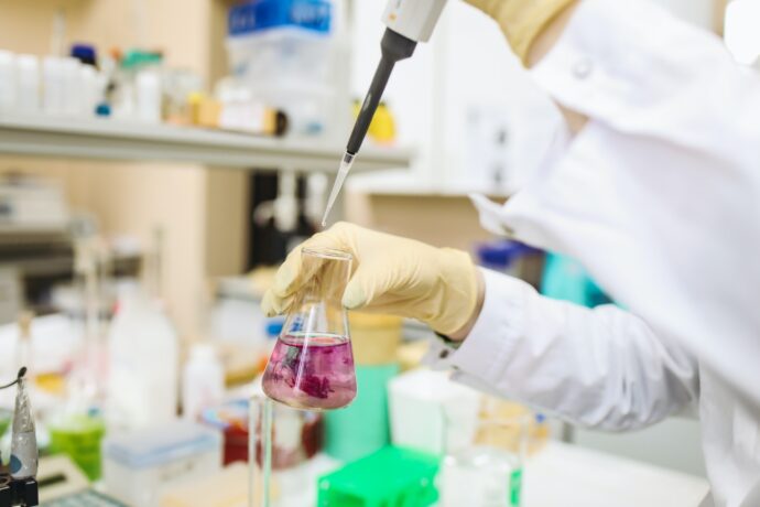 A scientist working in a laboratory with a flask.