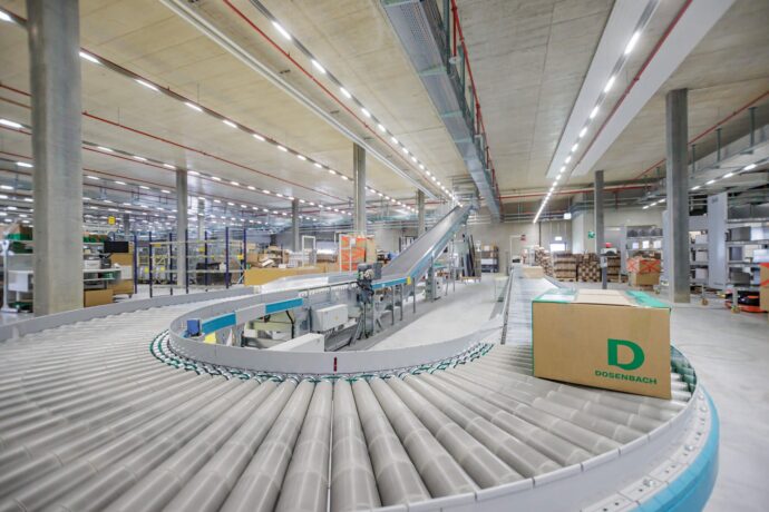 Kurvenf&ouml;rderband mit einem Dosenbach-Versandkarton im E-Commerce-Lager Luterbach