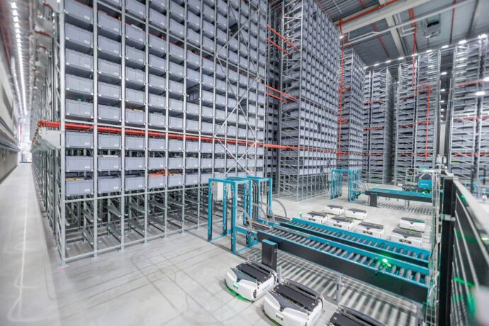 Blick in das 12 Meter hohe Skypod®-Hochregallager von Exotec bei Dosenbach-Ochsner in Luterbach mit 174.000 Lagerplätzen, Skypath®-Förderstrecken und Safelog-AGVs im Erdgeschossbereich.